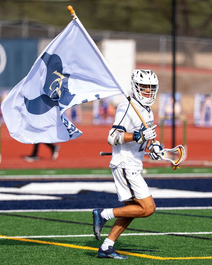 A Mavericks player running the LCC flag across the field